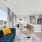 virtually staged living room with couch, breakfast bar seating and kitchen with stainless steel appliances