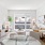 Model living room with plush couch seating, side tables with accessories and large open windows