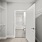 Walk in closet at our apartments for rent in Somerville, featuring carpeted flooring and a view of the bathroom.