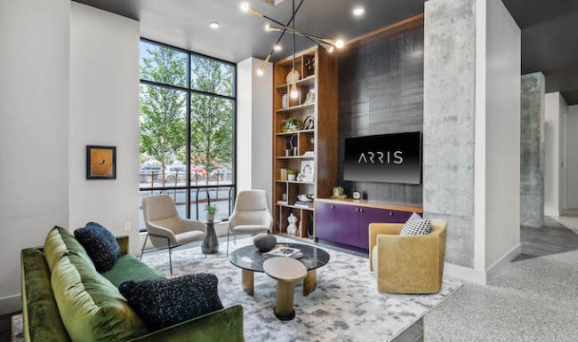 Resident lounge at our apartments for rent in Somerville, featuring couches, modern decor, and a flat screen TV.